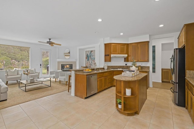 kitchen featuring stainless steel appliances, open floor plan, under cabinet range hood, and open shelves