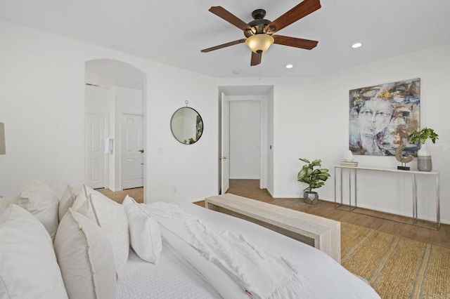 bedroom with arched walkways, ceiling fan, recessed lighting, and wood finished floors