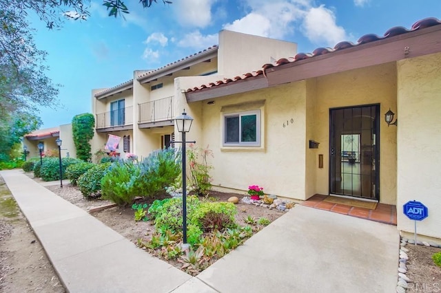 entrance to property featuring a balcony and stucco siding