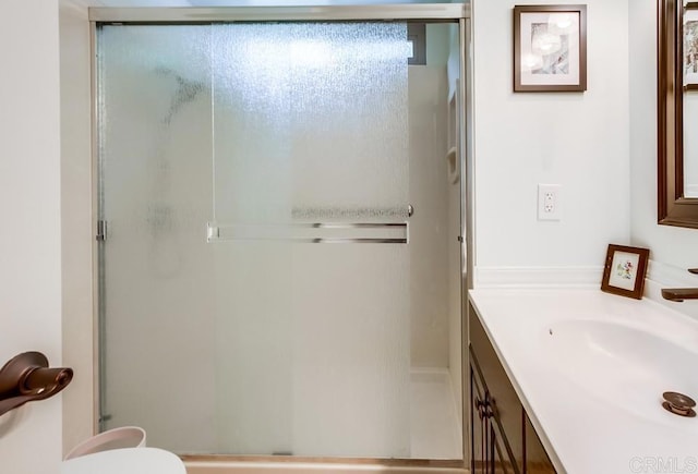 full bath featuring a stall shower, vanity, and toilet