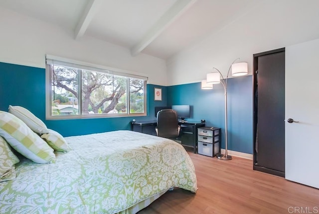 bedroom with vaulted ceiling with beams, wood finished floors, and baseboards