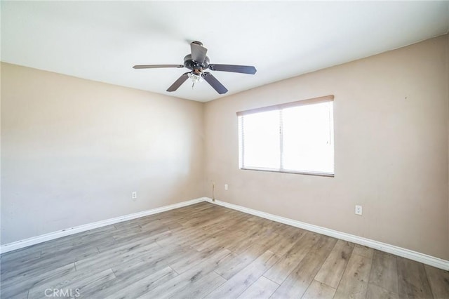 spare room featuring ceiling fan, wood finished floors, and baseboards