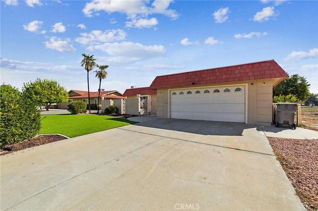 view of front of house featuring concrete driveway, mansard roof, a front lawn, and an attached garage