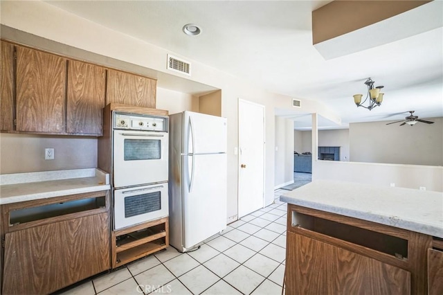 kitchen with white appliances, visible vents, light countertops, a fireplace, and light tile patterned flooring