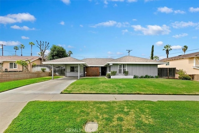 ranch-style home featuring a front lawn, a carport, driveway, and fence