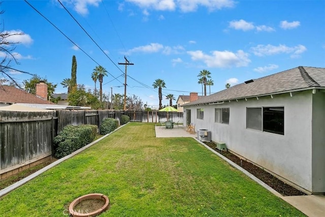 view of yard featuring central AC unit, a fenced backyard, and a patio area