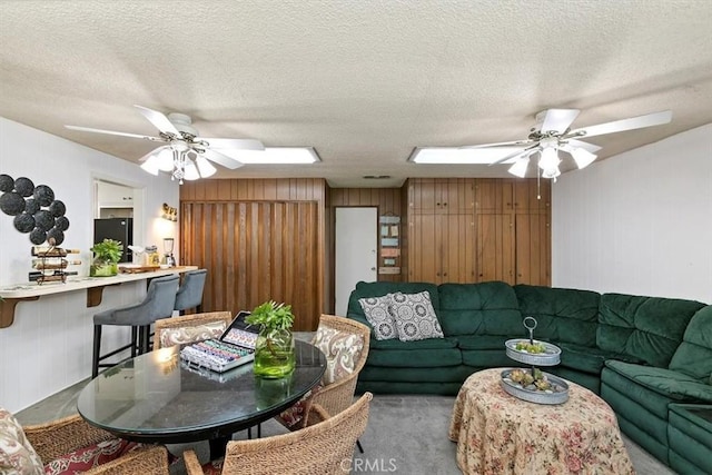 living room with a textured ceiling and ceiling fan