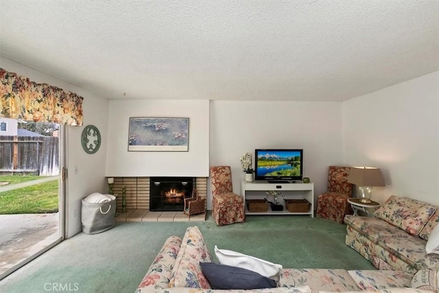 living area featuring carpet floors, a lit fireplace, and a textured ceiling