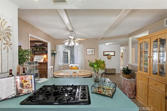 kitchen featuring wood finished floors, visible vents, ceiling fan, black gas cooktop, and a textured ceiling