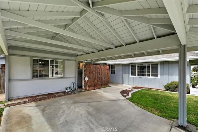 view of exterior entry with a lawn and board and batten siding