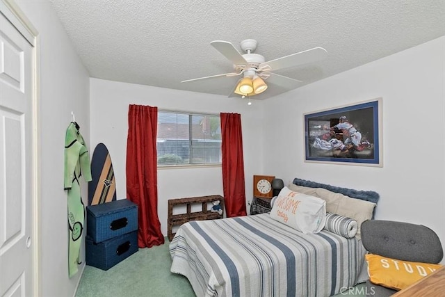 bedroom with carpet flooring, a textured ceiling, and a ceiling fan