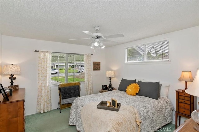 carpeted bedroom featuring a textured ceiling and a ceiling fan