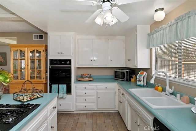 kitchen featuring black appliances, light countertops, visible vents, and a sink