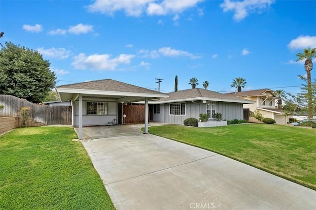 view of front of house with an attached carport, board and batten siding, a front lawn, fence, and driveway