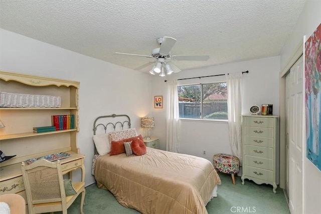 bedroom with a closet, carpet flooring, a textured ceiling, and a ceiling fan