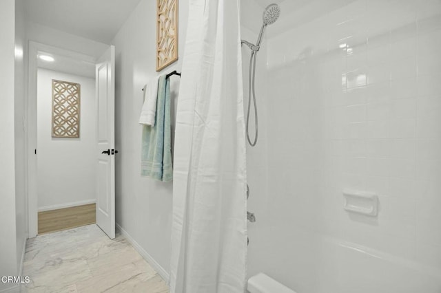 bathroom featuring marble finish floor, a shower with shower curtain, and baseboards