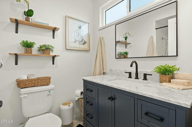 bathroom featuring a shower, toilet, and vanity