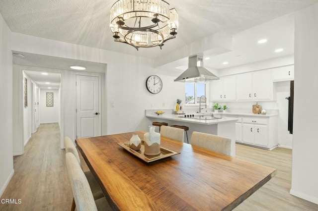 dining space featuring baseboards, an inviting chandelier, light wood-style flooring, recessed lighting, and a textured ceiling