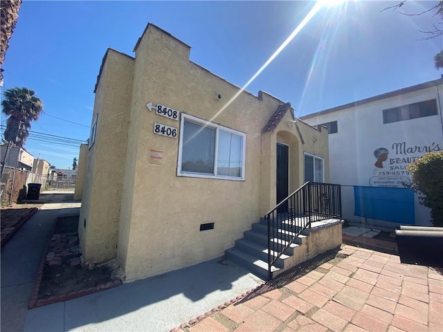 exterior space with crawl space and stucco siding