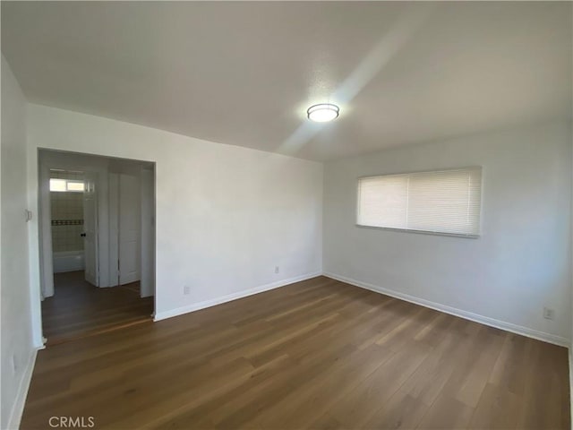 empty room with dark wood-style floors and baseboards