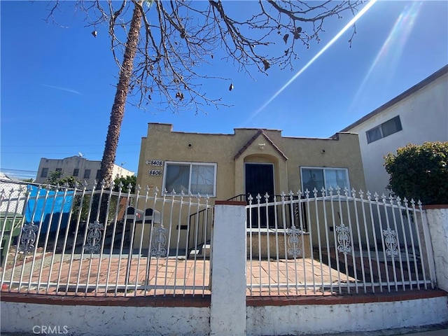 view of front of property with a fenced front yard and stucco siding