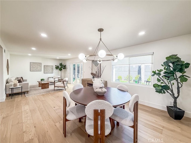 dining area featuring baseboards, light wood finished floors, recessed lighting, and a notable chandelier