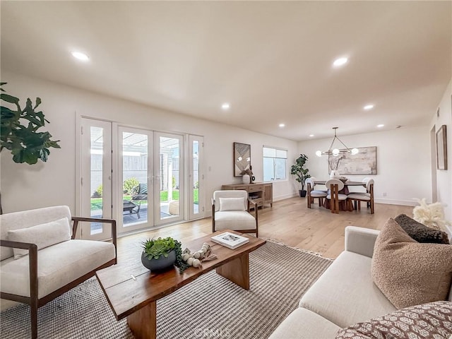 living room with light wood-style flooring, baseboards, a chandelier, and recessed lighting