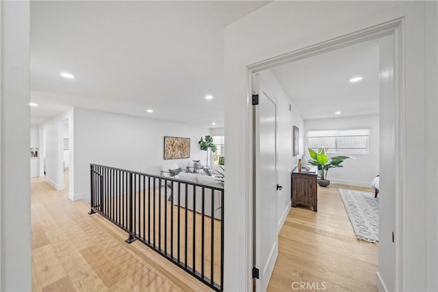 hallway featuring plenty of natural light, wood finished floors, and recessed lighting