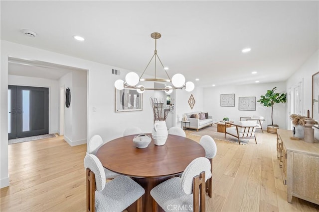 dining room with a notable chandelier, light wood finished floors, recessed lighting, visible vents, and baseboards