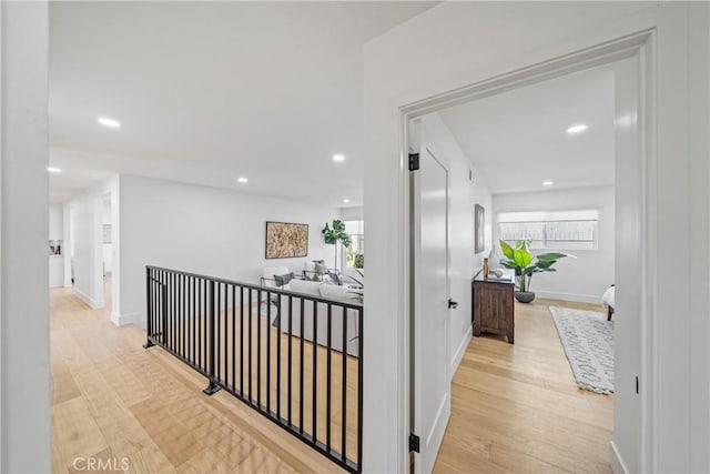 hallway featuring recessed lighting, plenty of natural light, and wood finished floors