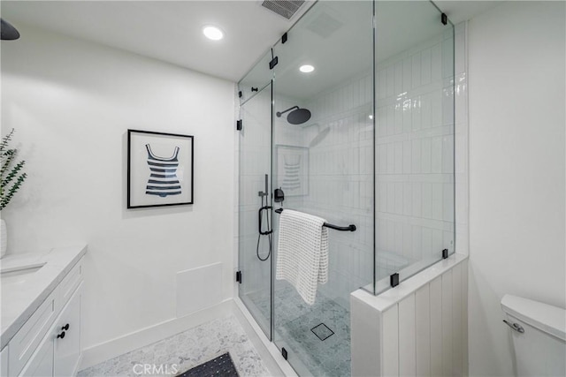 full bathroom featuring visible vents, baseboards, toilet, vanity, and a shower stall