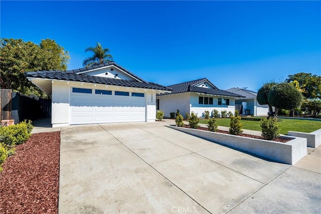 ranch-style house with driveway, a tiled roof, an attached garage, a front lawn, and stucco siding