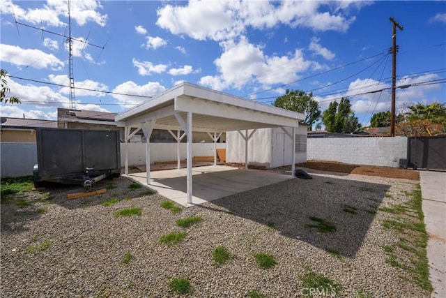 view of car parking featuring fence and a carport