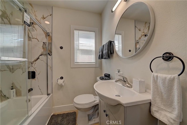 bathroom with toilet, baseboards, combined bath / shower with glass door, and vanity