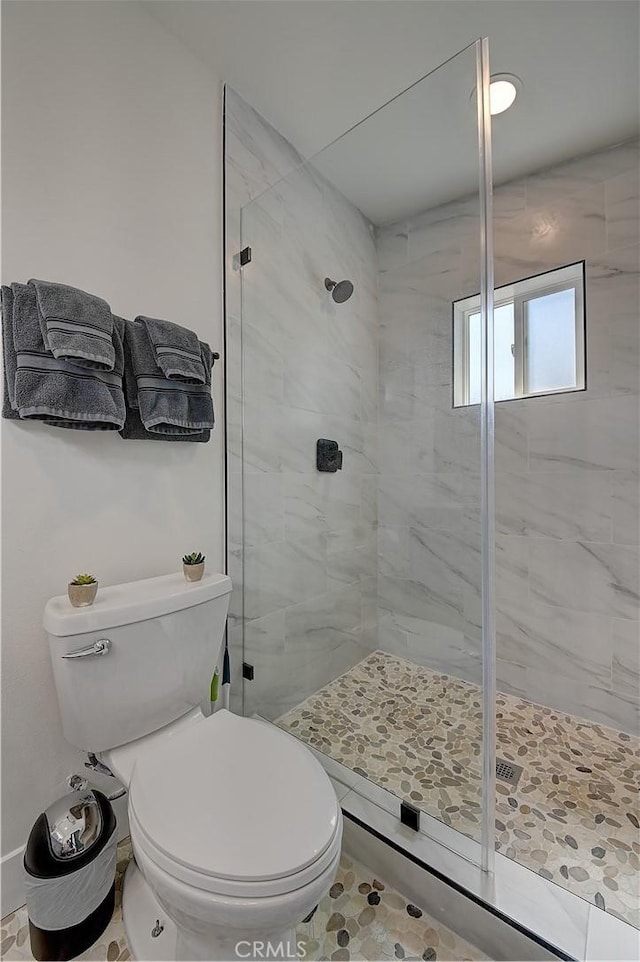 bathroom with toilet and a shower stall