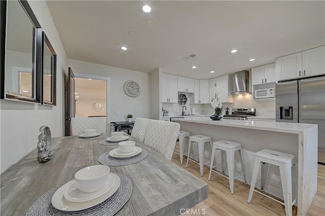 dining space featuring light wood-style flooring, visible vents, and recessed lighting