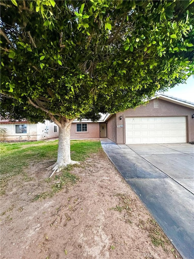 view of front of property featuring driveway, a garage, and stucco siding