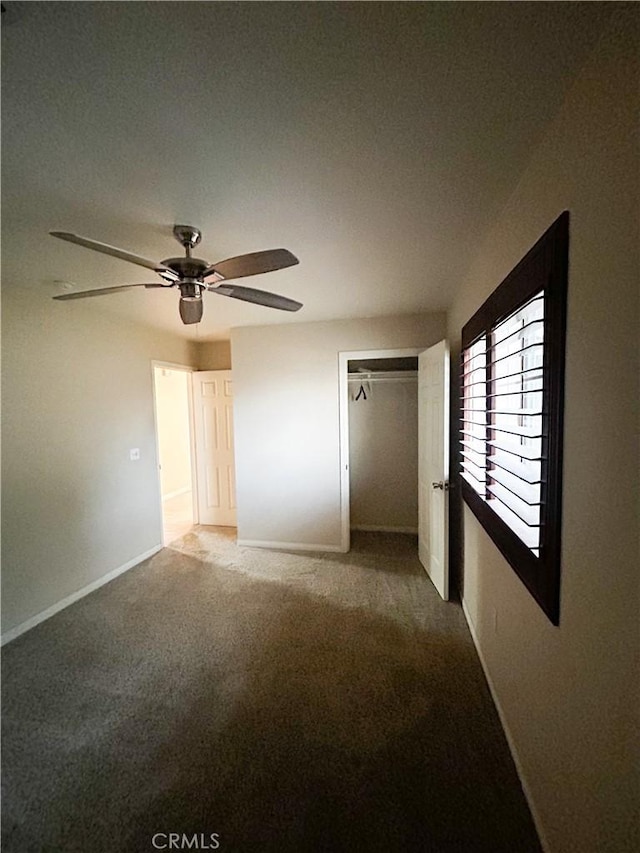 unfurnished bedroom featuring a ceiling fan, carpet, a closet, and baseboards