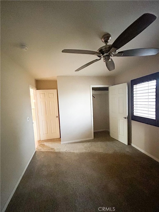 unfurnished bedroom featuring ceiling fan, a closet, baseboards, and carpet flooring