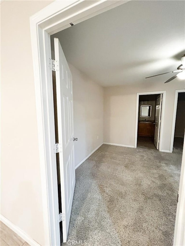 unfurnished room featuring carpet, baseboards, and a ceiling fan
