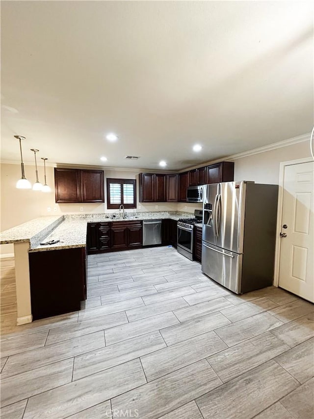 kitchen with wood finish floors, a sink, dark brown cabinets, ornamental molding, and appliances with stainless steel finishes