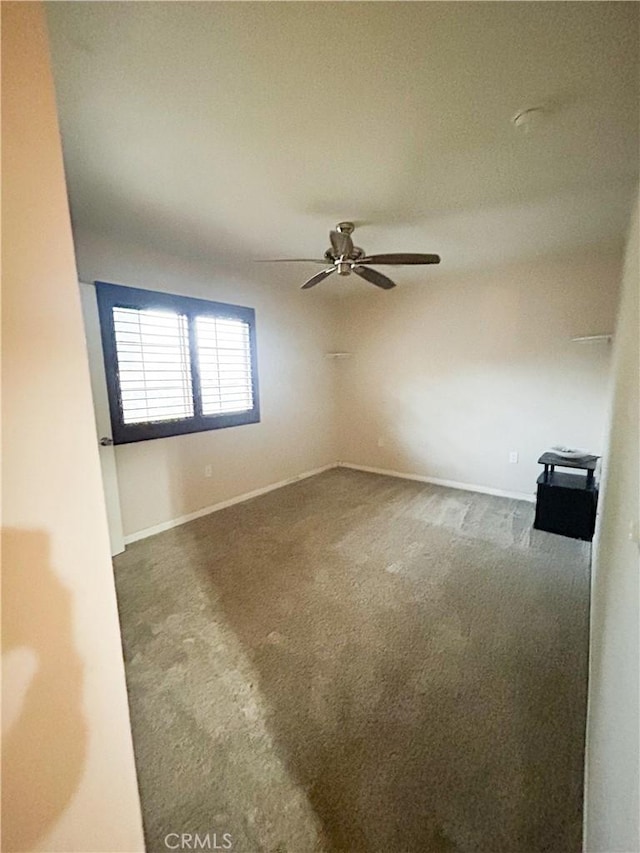 empty room featuring carpet floors, ceiling fan, and baseboards