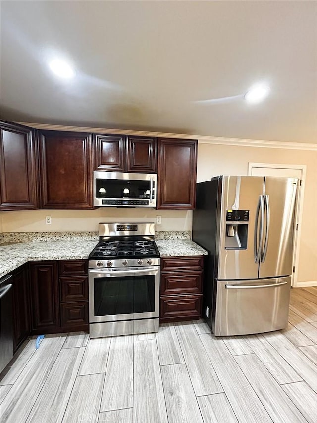 kitchen with stainless steel appliances, wood finish floors, dark brown cabinetry, and light stone countertops