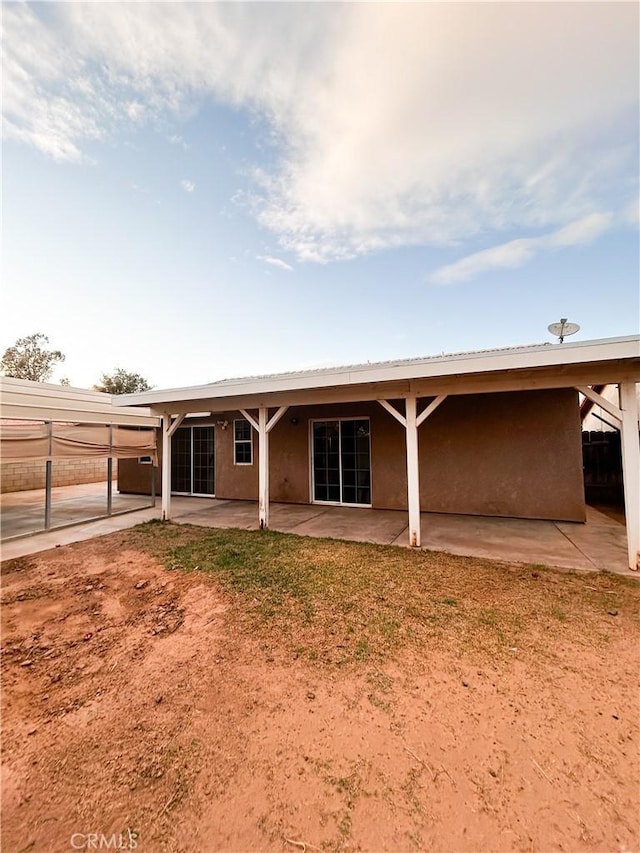 rear view of property featuring a patio area and stucco siding