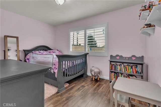 bedroom featuring wood finished floors and baseboards