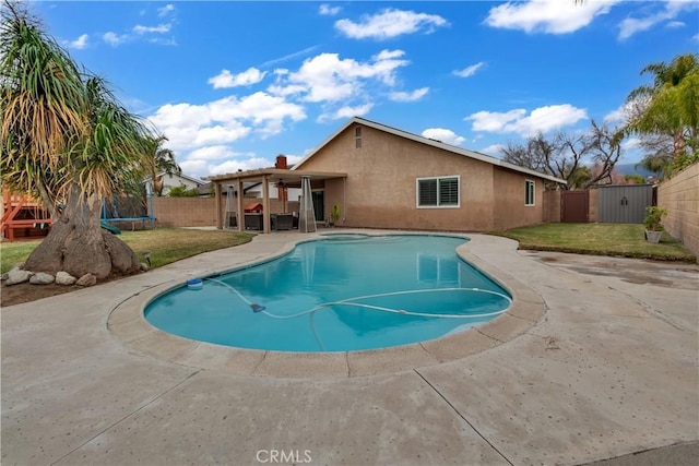 view of pool featuring a patio, a trampoline, a fenced backyard, and a lawn