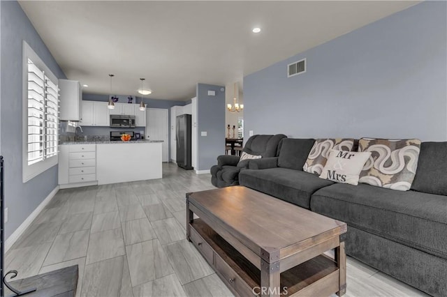 living room featuring recessed lighting, visible vents, baseboards, and a chandelier