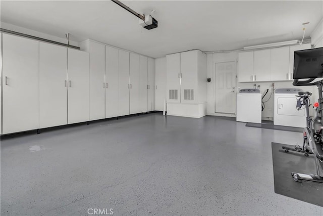 garage featuring a garage door opener and separate washer and dryer