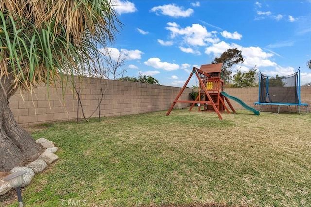 view of play area with a trampoline, a lawn, and a fenced backyard