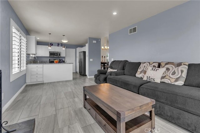 living room featuring visible vents, recessed lighting, baseboards, and an inviting chandelier